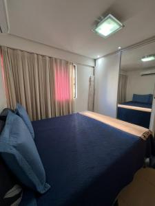 Un dormitorio con una cama grande con almohadas azules. en No melhor da Jatiuca, en Maceió 12 fotos más