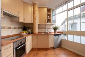 a kitchen with wooden cabinets and a large window at La Galeria in Vigo +7 photos