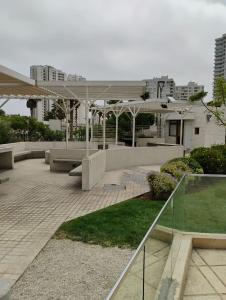 a building with a patio with benches and umbrellas at Marina 1 piso 23 in Coquimbo