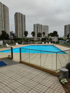 a large swimming pool in a city with tall buildings at Marina 1 piso 23 in Coquimbo +24 photos