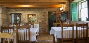 a restaurant with tables and chairs in a room at Casa Blanco in Palas de Rei
