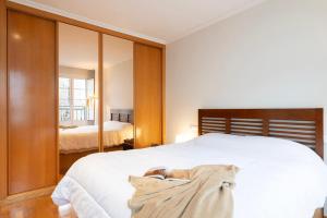 a bedroom with a white bed and a mirror at La Galeria in Vigo