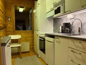 a small kitchen with a sink and a stove at Villa Oitola I Parking I Sauna I Wifi I Lake I Rural I Forest I Ideal for Aurora spotting in Sonka