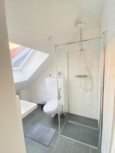 a bathroom with a glass shower and a toilet at Charmantes Studio-Apartment im Herzen von Neureut - Fußbodenheizung, Regendusche, Waschmaschine, Stellplatz in Karlsruhe