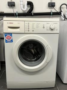 a white washing machine with a cord on top of it at Charmantes Studio-Apartment im Herzen von Neureut - Fußbodenheizung, Regendusche, Waschmaschine, Stellplatz in Karlsruhe