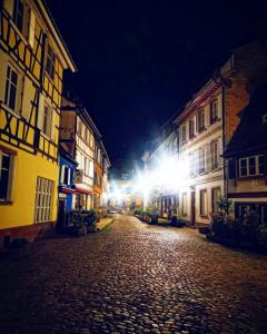a cobblestone street at night with buildings and lights at grand loft avec patio proche des quais Strasbourg in Strasbourg