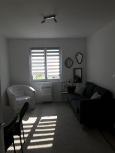 a living room with a couch and a window at Un sejour a Cabourg in Cabourg