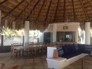 un pabellón con sofá, mesa y sillas en Casa Buena Vida Monterrico, en Taxisco