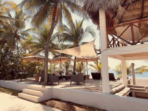 un complejo con sillas y sombrillas en la playa en Casa Buena Vida Monterrico, en Taxisco