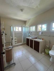 Un baño con ducha, lavabo e inodoro. en Casa Buena Vida Monterrico, en Taxisco