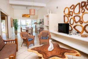 Una sala de estar con un sofá y un televisor. en Casa Buena Vida Monterrico, en Taxisco