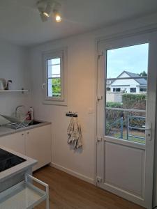 a kitchen with a door and a window and a sink at Maison de bord de mer à Hermanville-sur-mer in Hermanville-sur-Mer