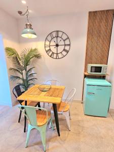 a dining room with a table and chairs and a clock at Apartamentos de la Huerta in Alicante +57 photos