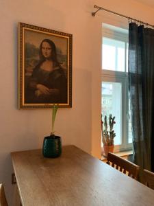 a dining room table with a picture of a woman at Hygge Home with free parking - Boho style apartment in Tartu