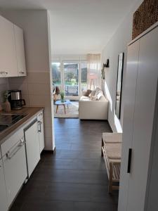 a kitchen and a living room with a couch at Ferienwohnung Lüttje Mööv an der Nordsee in Wangerland