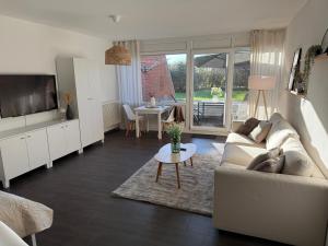 a living room with a couch and a table at Ferienwohnung Lüttje Mööv an der Nordsee in Wangerland +18 photos