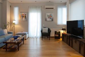 ein Wohnzimmer mit Couch und Flachbildfernseher in der Unterkunft Acropolis Luxury Apartment with Balcony in Athen