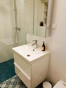a white bathroom with a sink and a shower at Dom pod Agatową Skałą we Wleniu in Wleń