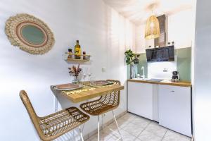 a small kitchen with a table and two chairs at Le Papucie 3 - Studio cosy - Cœur de Sarlat in Sarlat-la-Canéda