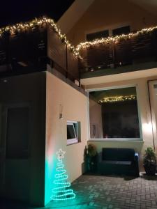 a christmas tree on the side of a house with lights at Casa Ramo in Râşnov