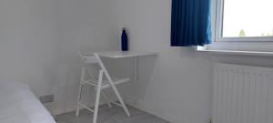 a white desk with a chair next to a window at London Travellers Room - Romford, Hornchurch, Gidea Park to Heathrow via Elizabeth line in Harold Wood