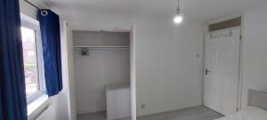 a bedroom with a closet with a door and a window at London Travellers Room - Romford, Hornchurch, Gidea Park to Heathrow via Elizabeth line in Harold Wood +17 photos