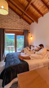 Pousada Vista do Céu في مونتي فيردي: رجل يستلقي على سرير في غرفة النوم