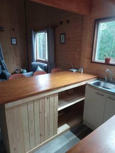 a kitchen with a wooden counter and a sink at Cabaña en el bosque con opción tina caliente in Puerto Varas