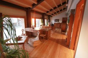 un soggiorno con pavimenti in legno, tavolo e sedie. di Agriturismo Richeton a Gaiarine