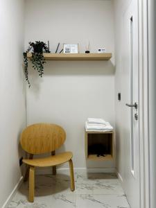 Habitación con silla de madera y TV. en Central Charm Apartment, en Tîrgu Neamţ