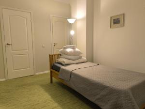 a bedroom with a bed with four pillows on it at TäheMaja7 in Viljandi