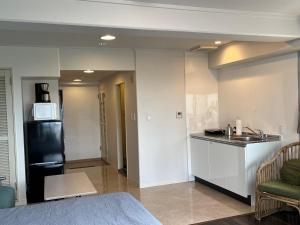 a kitchen with a sink and a black refrigerator at プリンスプラージュ901 in Onna