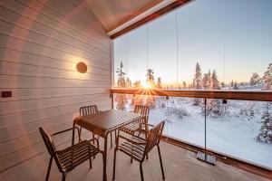 a balcony with a table and chairs and a window at Peak Chalet by Aavalevi Holidays, Ski-in Ski-out, Mountain View in Levi