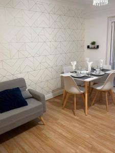 ein Esszimmer mit Tisch und Couch in der Unterkunft Lovely Spacious House Family & Contractor Friendly 3 Bedroom Near Leeds Centre Sleeps 8 in Beeston