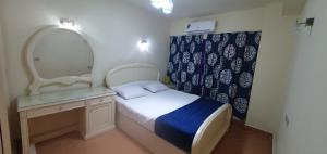 ein kleines Schlafzimmer mit einem Bett und einem Spiegel in der Unterkunft Gamal SEA BEACH Flat in Sharm El Sheikh