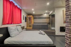 Un dormitorio con una cama grande con una cortina roja. en street Loft with sauna, en Saint-Étienne