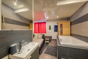 Un baño con bañera, lavabo y bañera. en street Loft with sauna, en Saint-Étienne