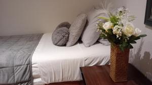 a bedroom with a bed with a vase of flowers on a table at Number 14 in Ipswich