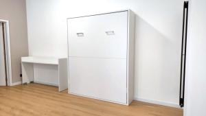 a white refrigerator in a room with a table at Le Cocon Studio in Brussels