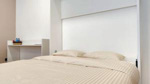 a white bedroom with a bed with a white headboard at Le Cocon Studio in Brussels
