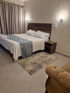 a bedroom with a large bed and a couch at Noura Suites in Ukunda