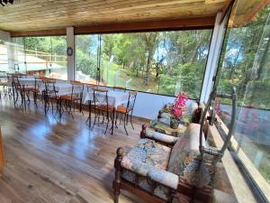 a living room with a couch and tables and chairs at Recanto Ursa Maior in Monte Verde