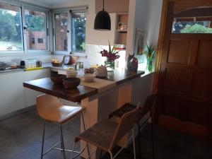 a kitchen with a counter with chairs and a table at Hermosa casa de diseño en las lomas in Miramar