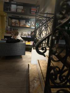 una mujer sentada en un sofá en una sala de estar en Hôtel Sèvres Saint Germain, en París