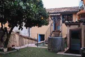 a house with a staircase and a tree in a yard at Apartamentos El Pozo 2 in Villanueva de la Vera