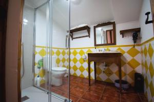a bathroom with a toilet and a glass shower at Apartamentos El Pozo 2 in Villanueva de la Vera +9 photos