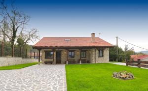 a house with a green lawn and a house at Casa Rural El Ribero II in Montiano de Mena