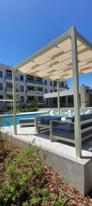 een picknicktafel onder een paviljoen naast een gebouw bij Complejo Cantal Porto in Salta