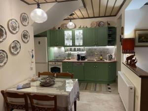 a kitchen with green cabinets and a table with chairs at Petrini Armonia, Vitsa Zagori in Vitsa