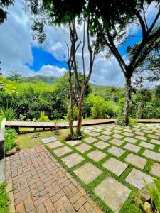 a garden with trees and a brick walkway at Estalagem Cachoeira do Pimenta in Cunha